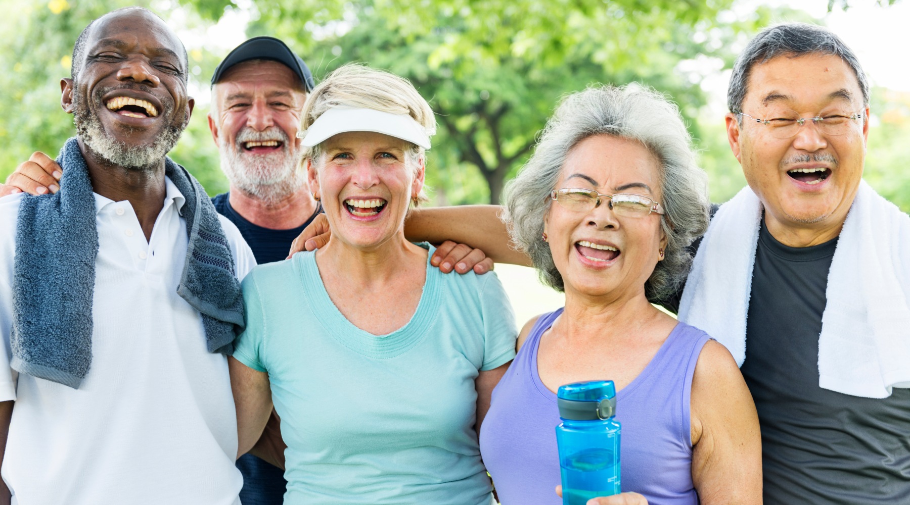 A group of people smiling for a photo at Viva Bene St. Peters apartments in St. Peters, MO, featuring a backdrop of trees. A group of people smiling for a photo at Viva Bene St. Peters apartments in St. Peters, MO, featuring a backdrop of trees.