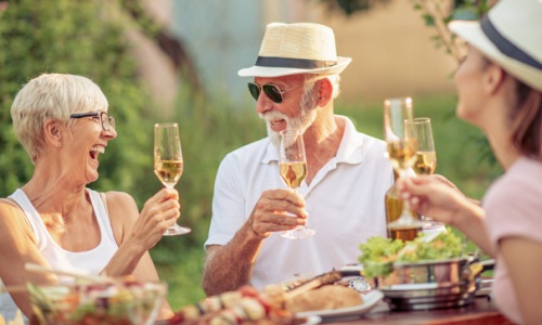 people have dinner outdoors with wine